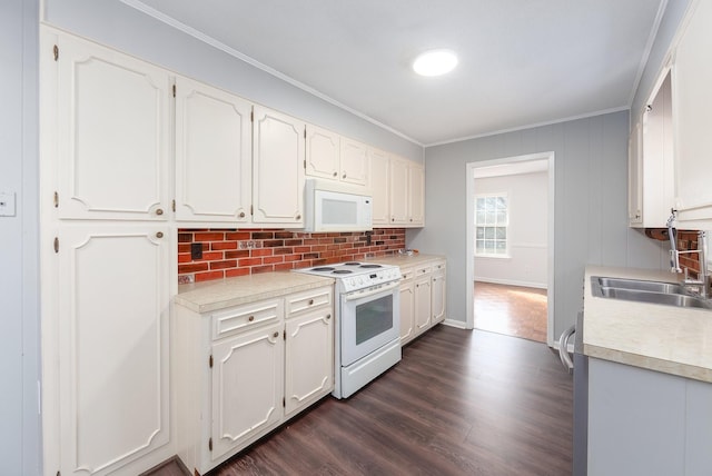 kitchen featuring white appliances, a sink, white cabinets, light countertops, and dark wood finished floors