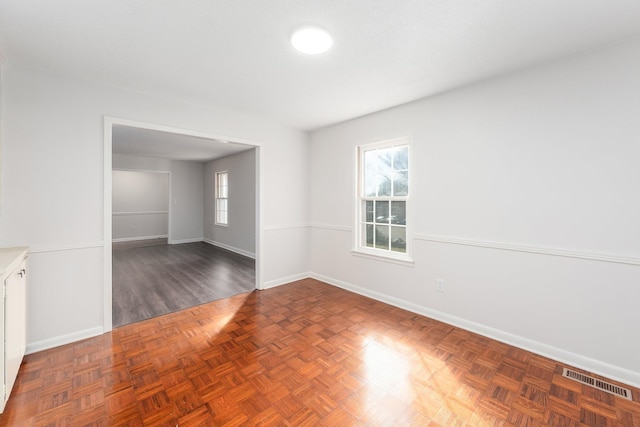 unfurnished room with visible vents and baseboards