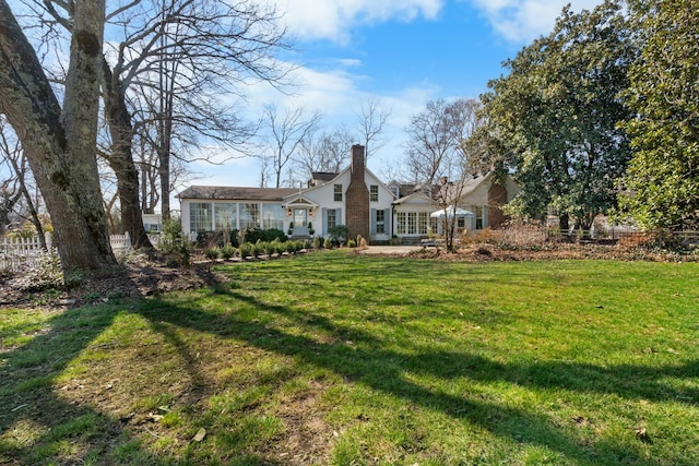 rear view of property featuring a yard and a chimney