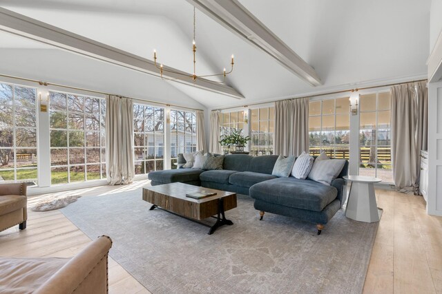 sunroom featuring vaulted ceiling with beams