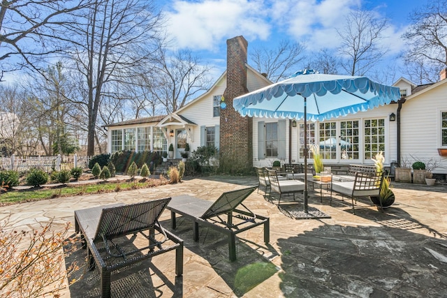 rear view of property featuring a patio area, a chimney, and fence