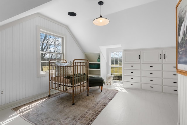 sitting room with lofted ceiling, plenty of natural light, and wood finished floors