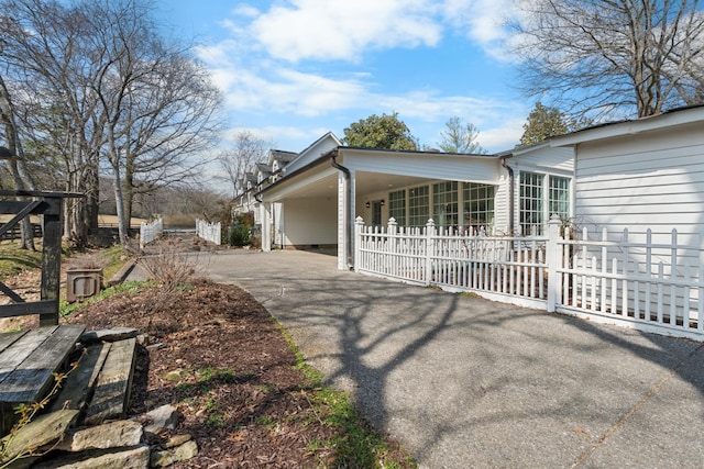 view of side of home with driveway, crawl space, fence, and an attached carport