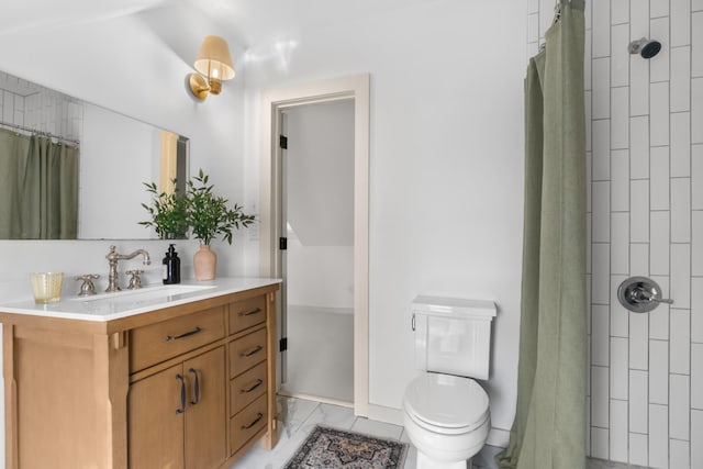 bathroom featuring marble finish floor, a tile shower, vanity, and toilet