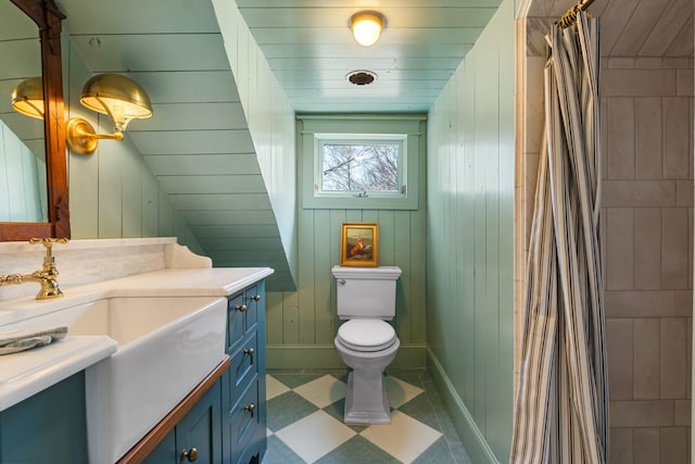 full bathroom with a shower with shower curtain, wood walls, vanity, and toilet