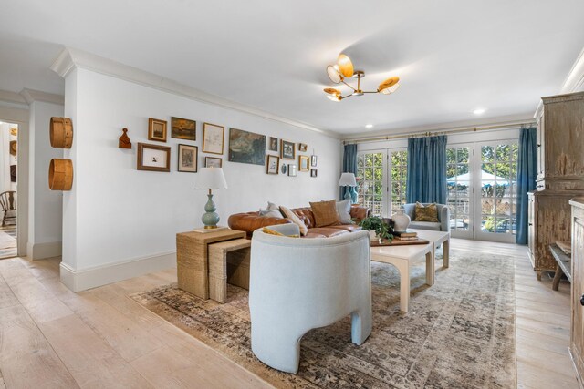 living area featuring ornamental molding, light wood-style flooring, and baseboards