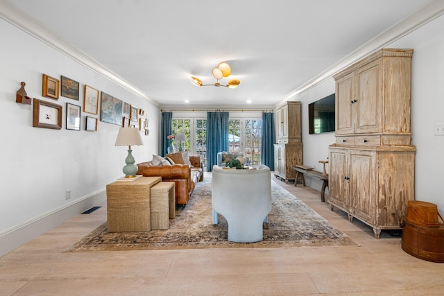 living area featuring light wood-type flooring, visible vents, ornamental molding, and baseboards