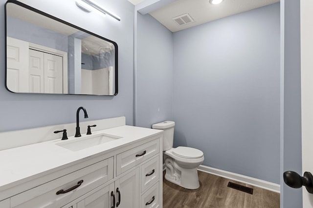 full bathroom with visible vents, vanity, toilet, and wood finished floors