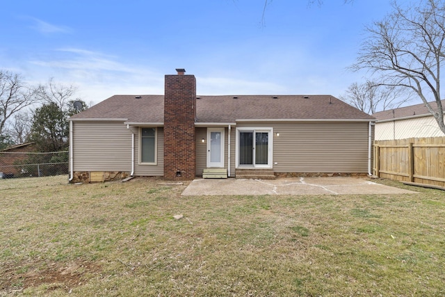 back of property with a yard, a chimney, a patio, and a fenced backyard