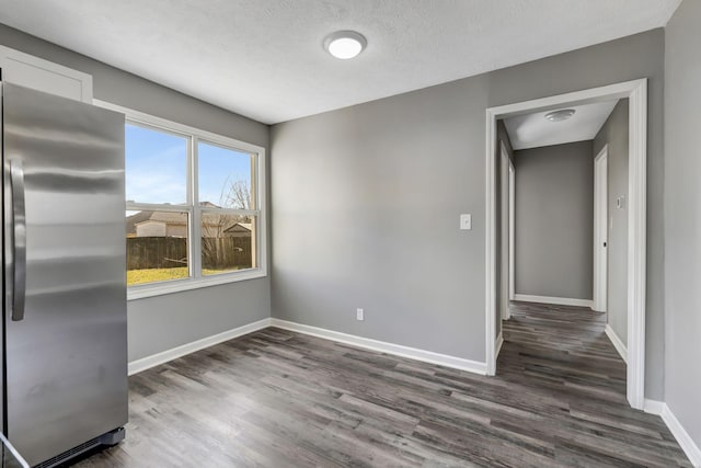 interior space featuring a textured ceiling, baseboards, and dark wood-type flooring