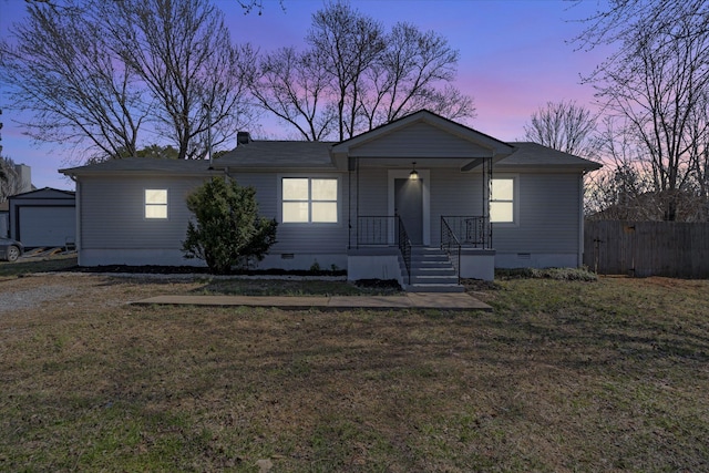 view of front of home featuring crawl space, fence, an outbuilding, and a front yard