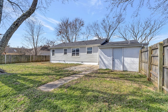 rear view of house with crawl space, a fenced backyard, and a lawn