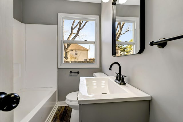 bathroom featuring wood finished floors, vanity, toilet, and baseboards