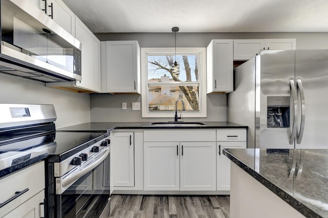 kitchen with appliances with stainless steel finishes, white cabinets, and a sink