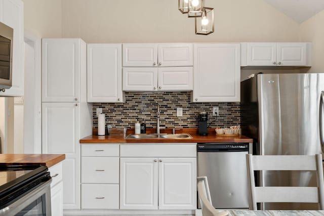 kitchen featuring a sink, decorative backsplash, stainless steel appliances, and wooden counters