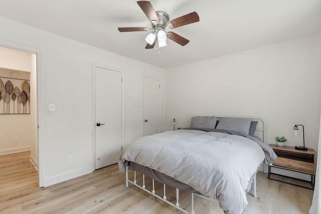 bedroom with light wood-type flooring, ceiling fan, and baseboards