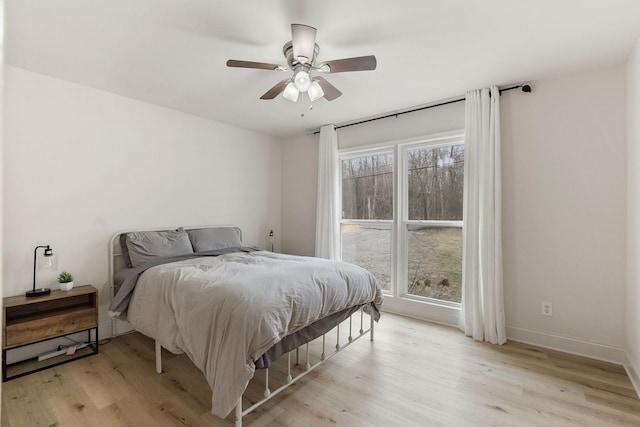 bedroom featuring light wood-style floors, ceiling fan, and baseboards