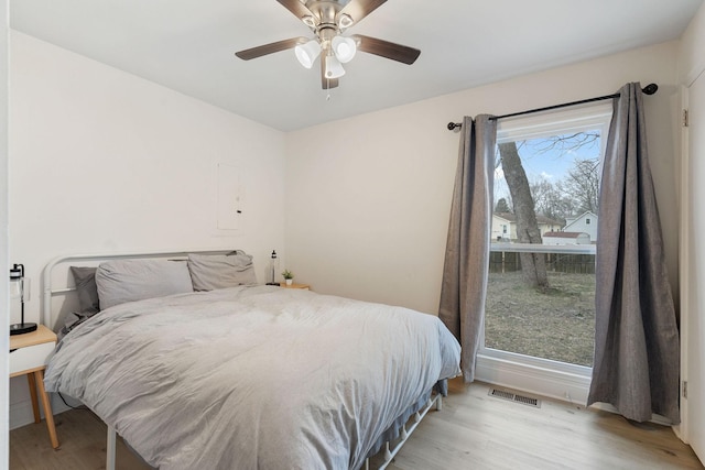 bedroom featuring visible vents, ceiling fan, and wood finished floors