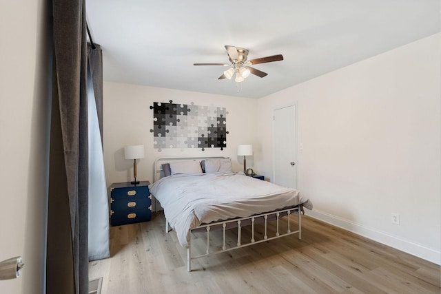 bedroom featuring visible vents, wood finished floors, a ceiling fan, and baseboards