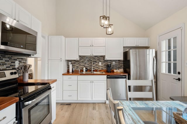 kitchen featuring a sink, wood counters, white cabinets, appliances with stainless steel finishes, and light wood finished floors