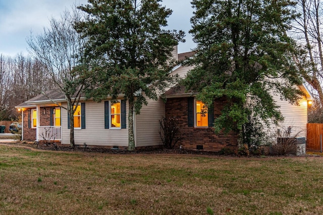 view of front facade featuring a front yard, crawl space, and brick siding