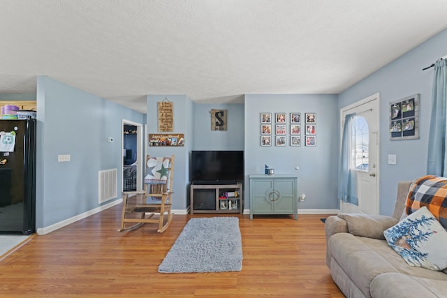 104 Allen St, Alexandria, TN 37012 - living area with a textured ceiling, light wood-style flooring, visible vents, and baseboards