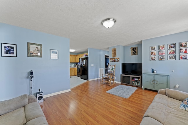 104 Allen St, Alexandria, TN 37012 - living area featuring light wood-type flooring, a textured ceiling, and baseboards