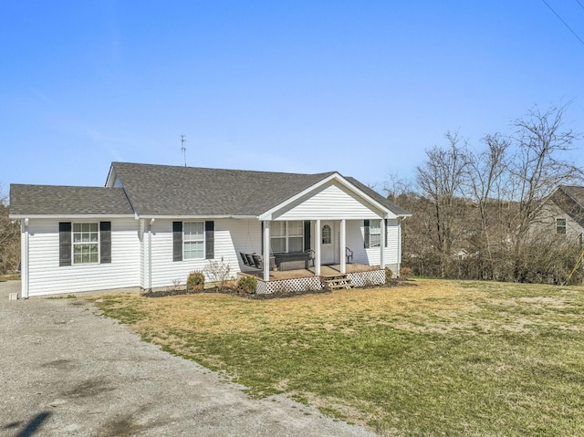 view of front of house featuring roof with shingles, a porch, and a front yard