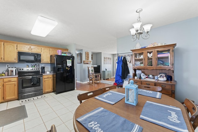 104 Allen St, Alexandria, TN 37012 - kitchen with light tile patterned flooring, a notable chandelier, light countertops, black appliances, and pendant lighting