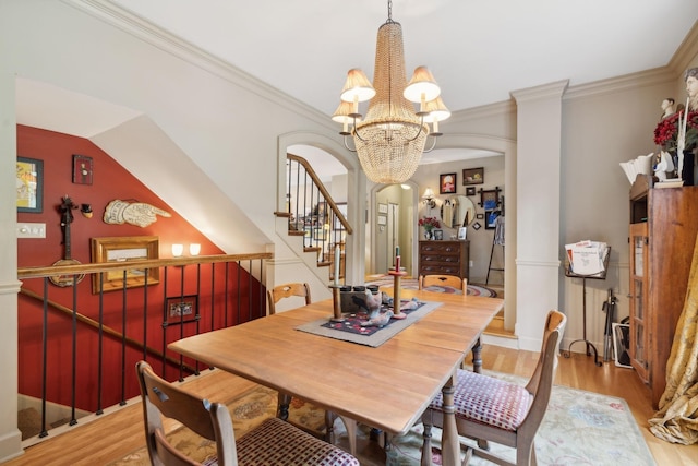 dining room featuring crown molding, arched walkways, and wood finished floors