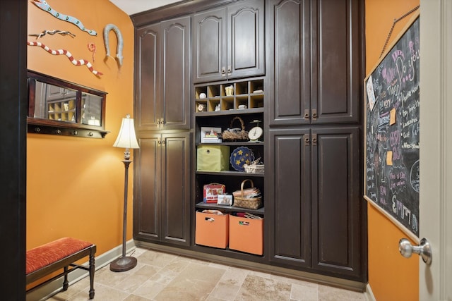 mudroom with stone finish floor and baseboards