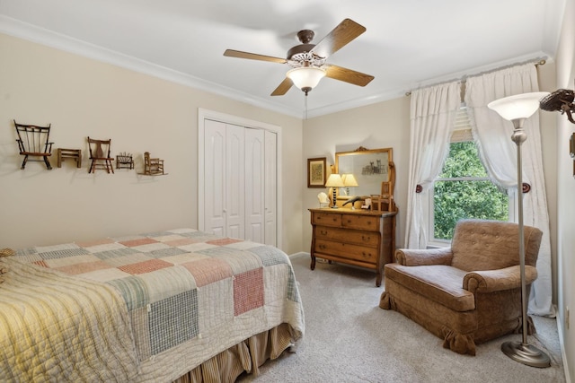 bedroom featuring ceiling fan, ornamental molding, a closet, and light colored carpet