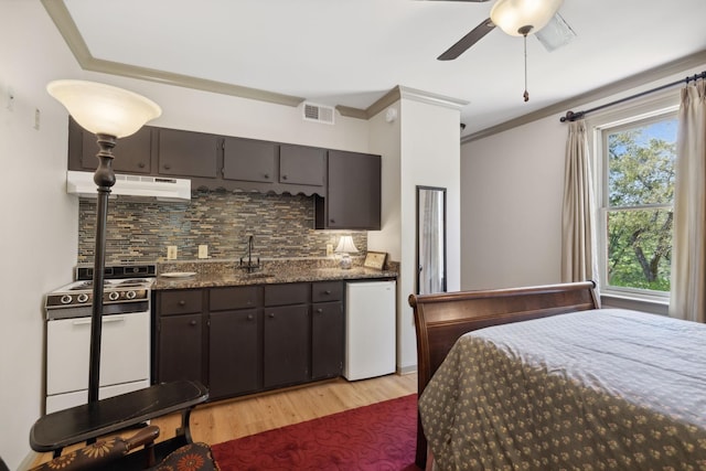 bedroom featuring light wood finished floors, crown molding, visible vents, and a sink