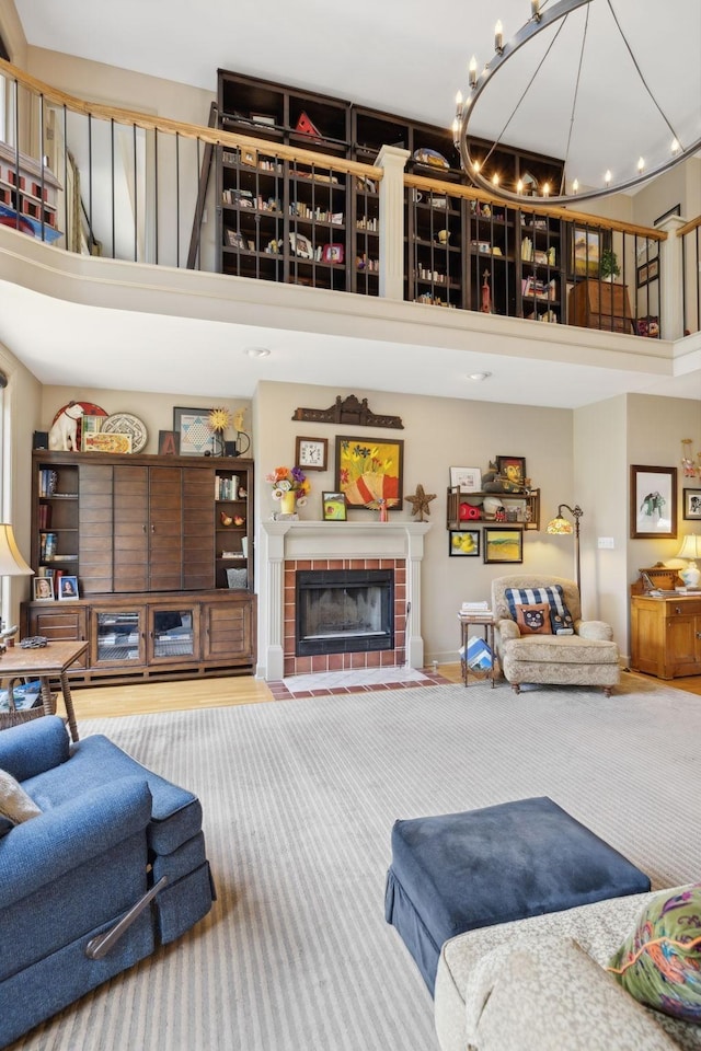 living area featuring a fireplace, a high ceiling, and an inviting chandelier