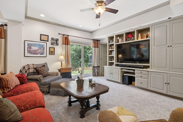 living area featuring ceiling fan, recessed lighting, light colored carpet, built in desk, and crown molding