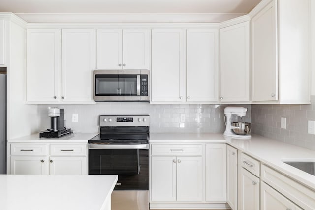 kitchen featuring appliances with stainless steel finishes, white cabinets, and decorative backsplash