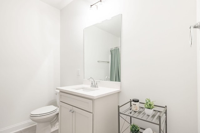 bathroom featuring baseboards, vanity, and toilet