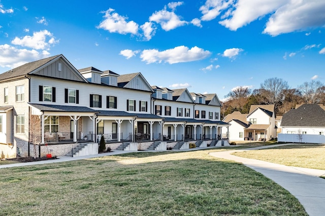 view of front of house with board and batten siding, a residential view, covered porch, and a front yard