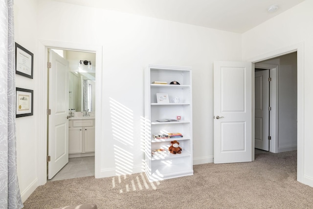 hallway featuring carpet floors and a sink