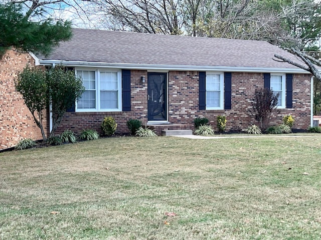 single story home with roof with shingles, a front lawn, and brick siding