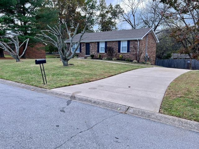 ranch-style home with roof with shingles, fence, a front lawn, and brick siding