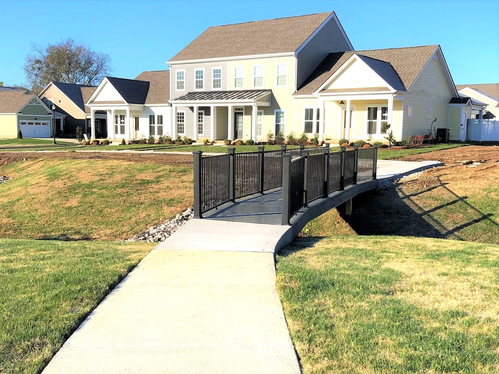 view of front of house with cooling unit and a front lawn