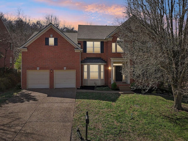 traditional-style house with driveway, brick siding, a lawn, and an attached garage