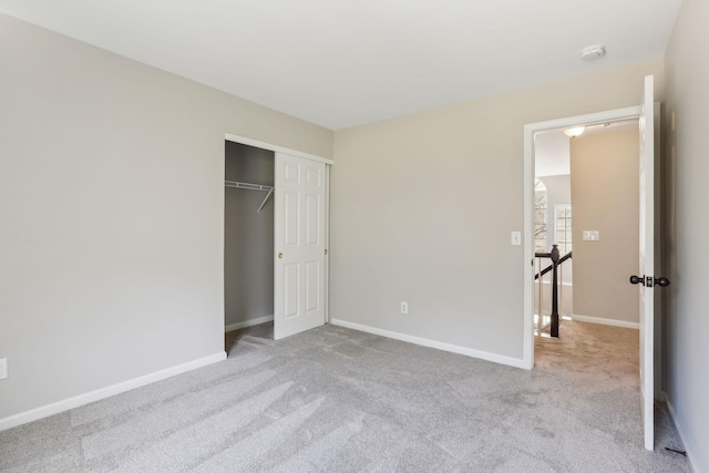 unfurnished bedroom featuring carpet floors, baseboards, and a closet