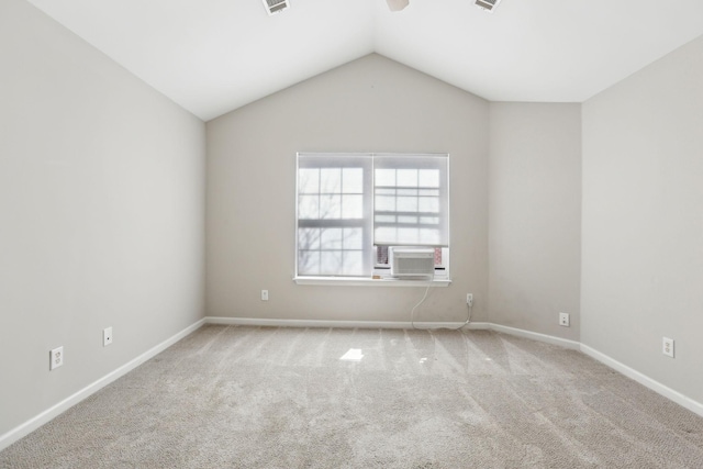 carpeted empty room with visible vents, vaulted ceiling, and baseboards