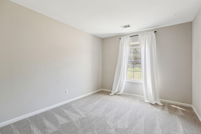 carpeted spare room with baseboards and visible vents