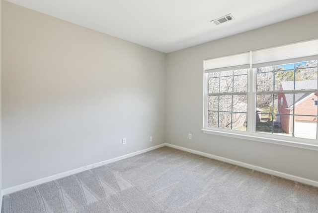 unfurnished room featuring baseboards, visible vents, and light colored carpet