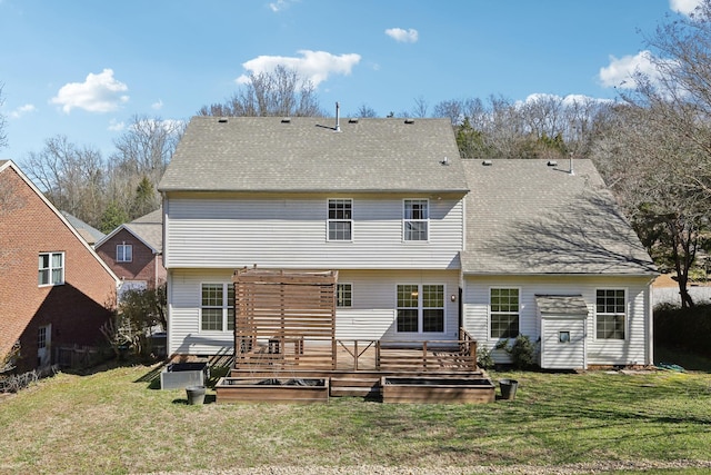 back of house with a shingled roof, a yard, and a wooden deck