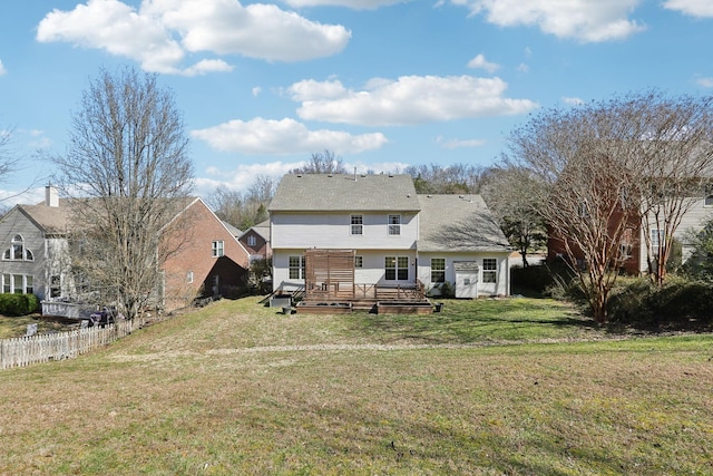 back of house with a deck, a yard, and fence