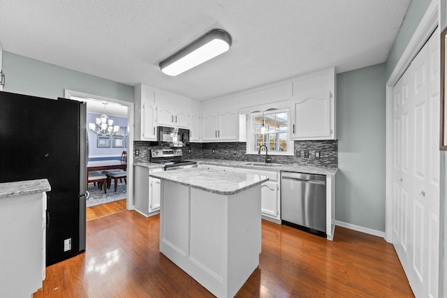 kitchen with stainless steel appliances, dark wood-style flooring, white cabinetry, and a sink